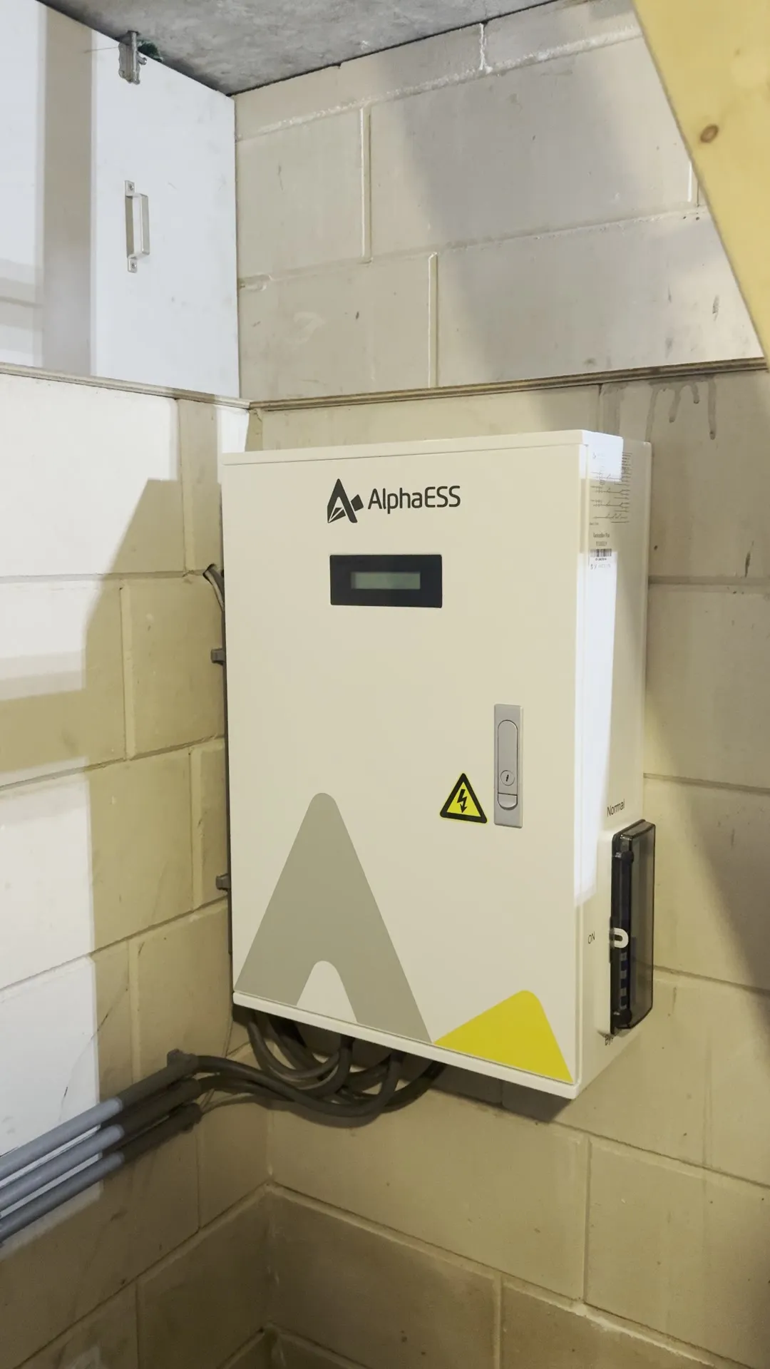 AlphaESS Backup Box met display en schakelaar aan een lichte muur in een kelder