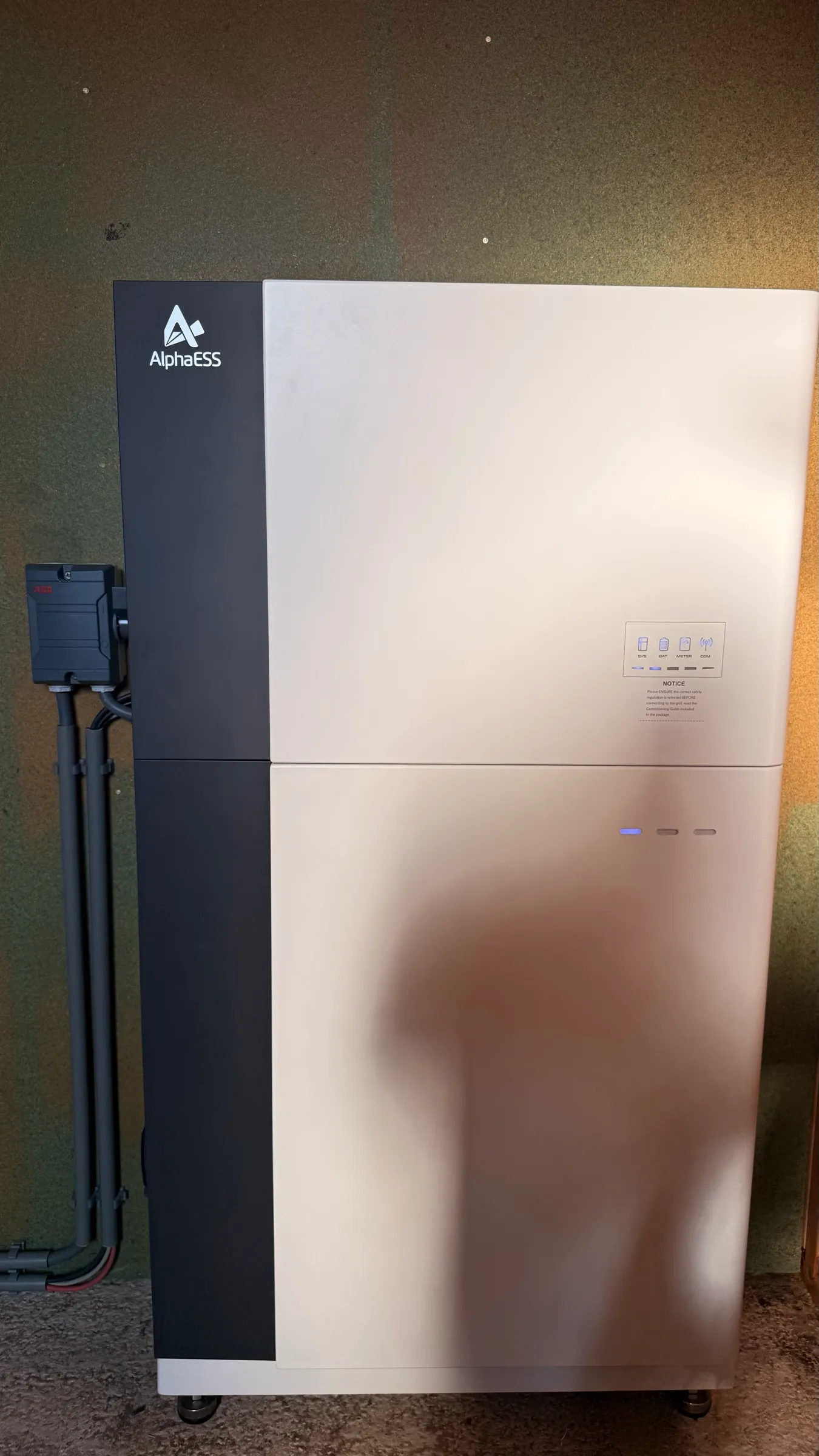 AlphaESS-thuisbatterij van 9,3 kWh: omvormer en één batterijmodule tegen een donkere wand