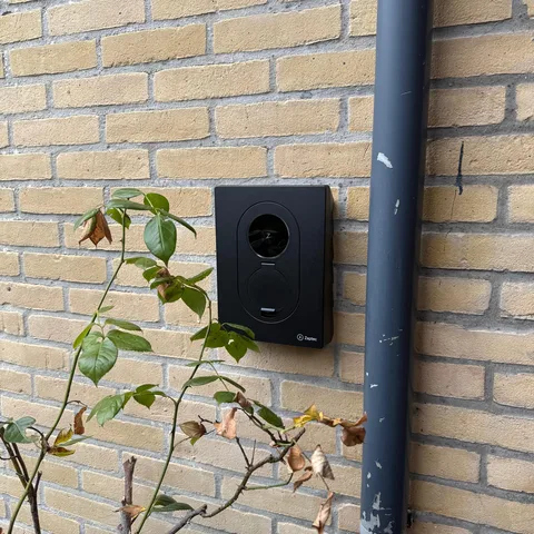Zwart Zaptec laadpunt aan een gele bakstenen gevel in Veenendaal