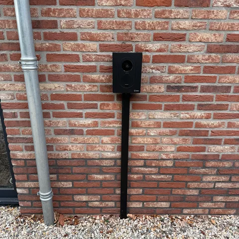 Laadpaal op een paal naast de regenpijp aan een woning in Zeist