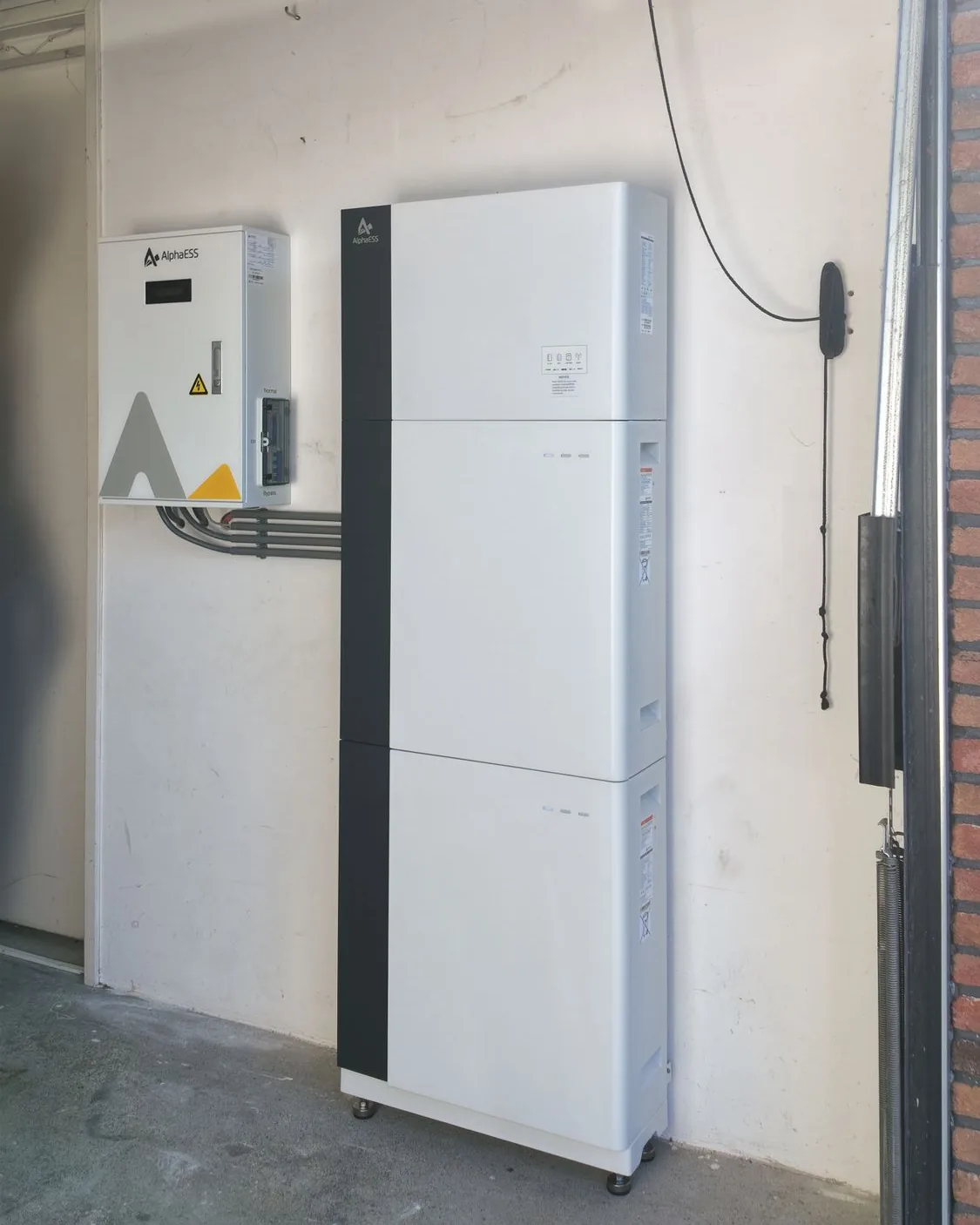 AlphaESS thuisbatterij en AlphaESS-schakelkast, netjes aan de muur van een garage geplaatst door Fixentra